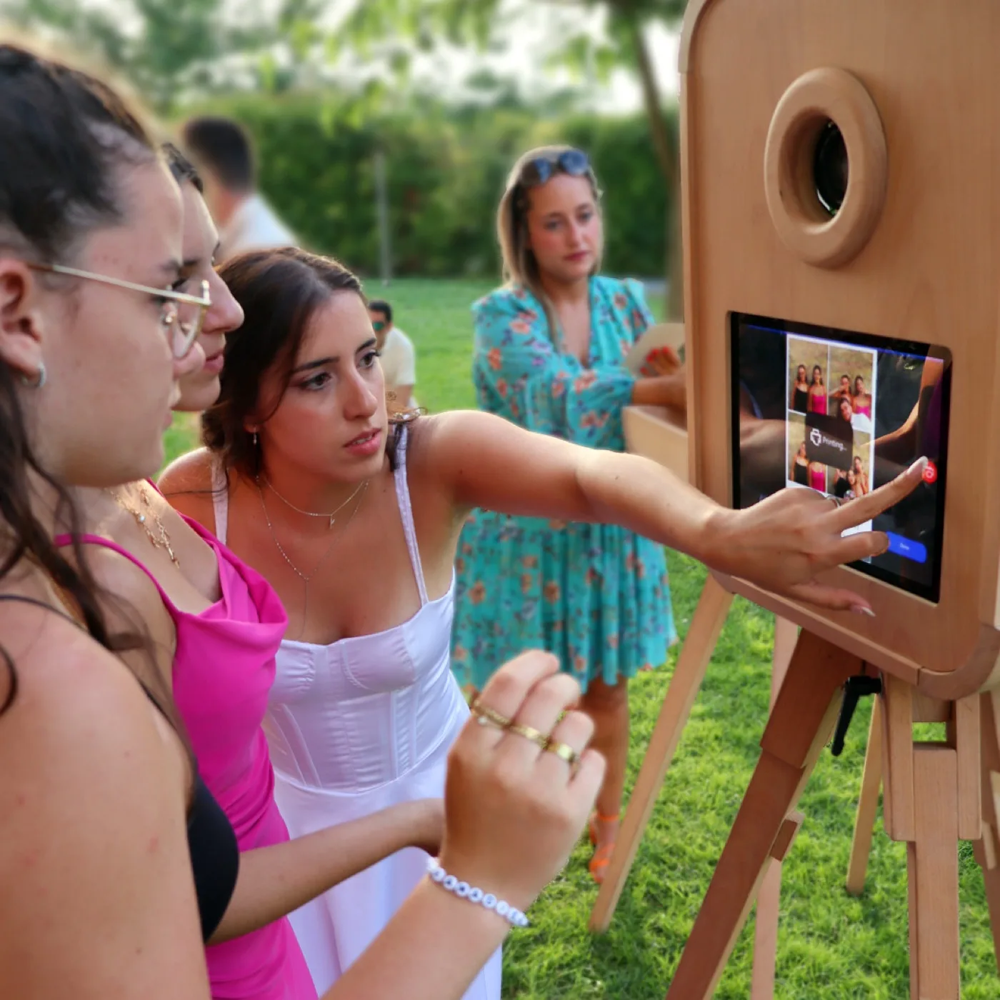 Invitadas usando la pantalla táctil del fotomatón vintage