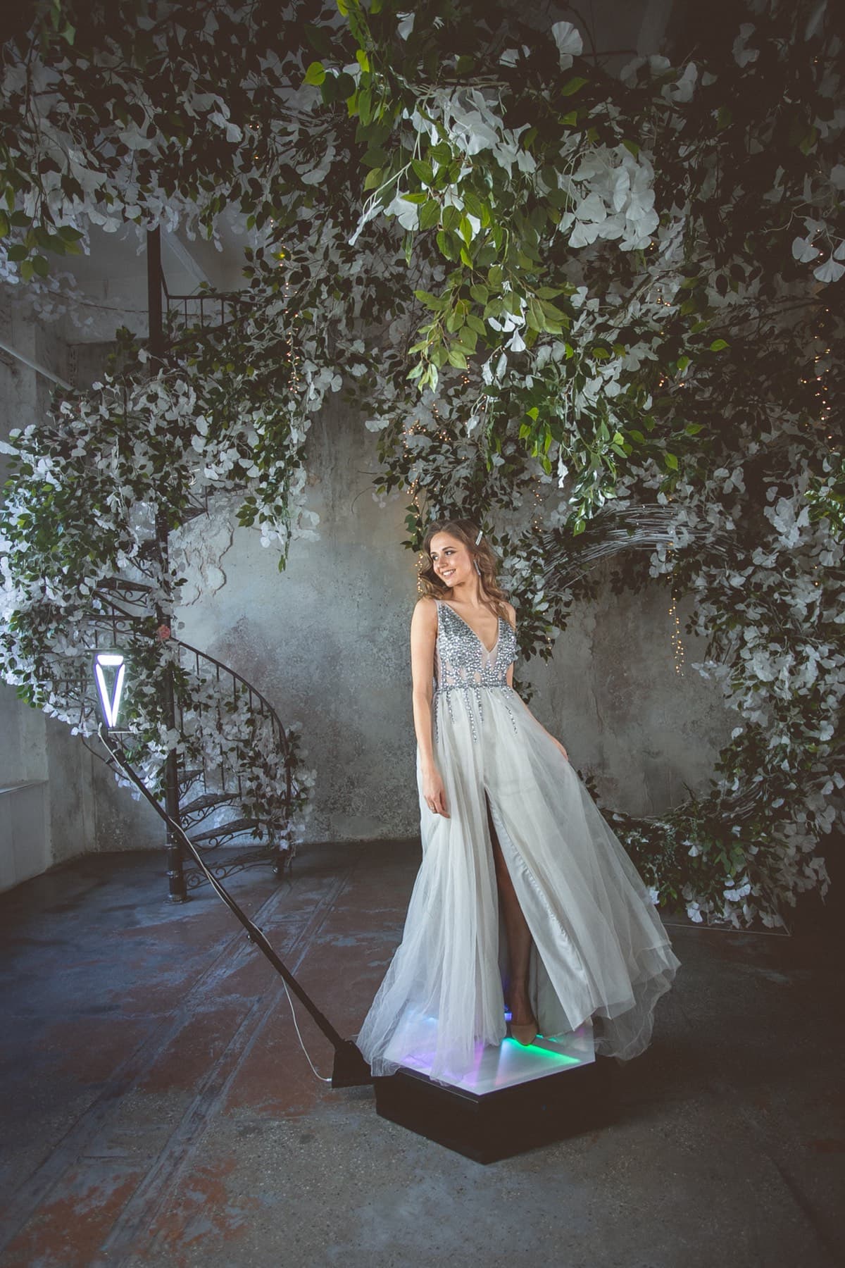 Invitada con vestido elegante en la plataforma del fotomatón 360
